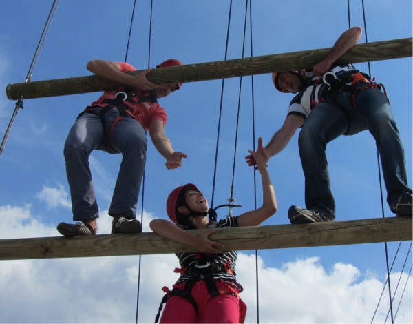 Drei junge Teilnehmer helfen sich bei der Bewltigung eines Kletterelements
