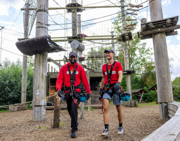 Praktikum PirateRock Zwei Mitarbeiter des Kletterparks stehen am Empfangstresen und lächeln in die Kamera
