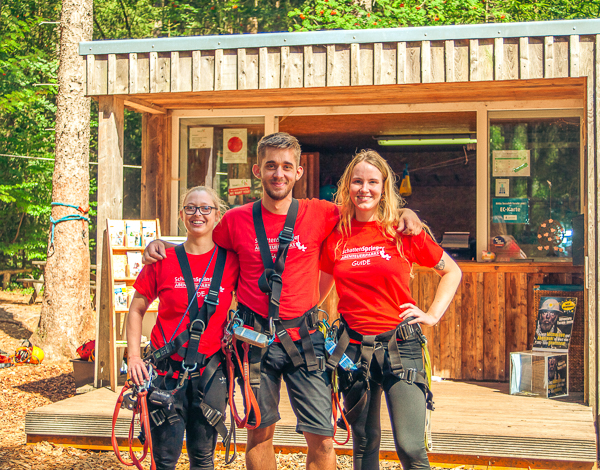 Praktikum TreeRock Zwei Mitarbeiter des Kletterparks stehen am Empfangstresen und lächeln in die Kamera